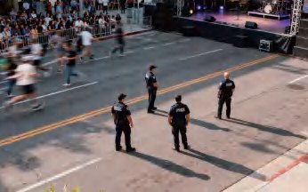 Luftaufnahme einer abgesperrten Laufveranstaltung, Polizeikräfte sichern die Strecke