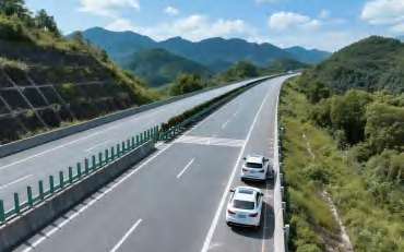Luftaufnahme einer Autobahn durch bergiges Gelände mit fahrenden Fahrzeugen