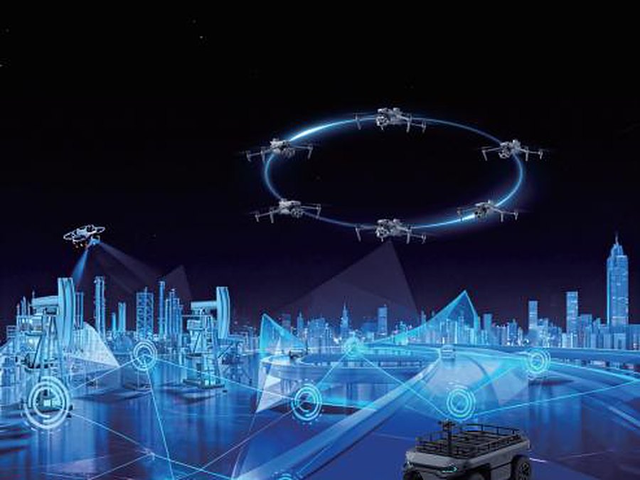 Visualisierung eines vernetzten Drohnenverbunds über einer Stadt mit angebundenem Bodenfahrzeug